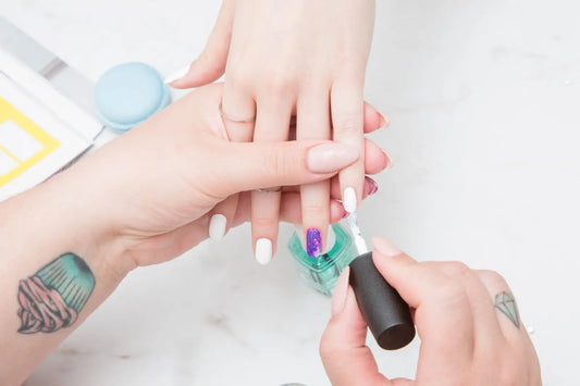 Someone painting a girl's nails