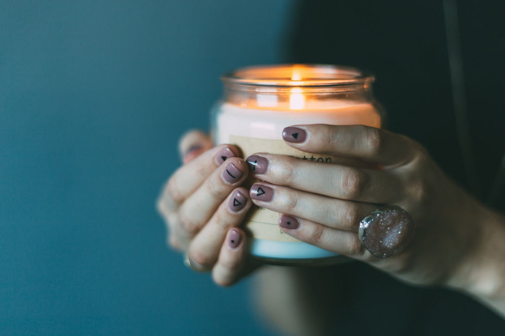 Lady with painted nails holding a candle