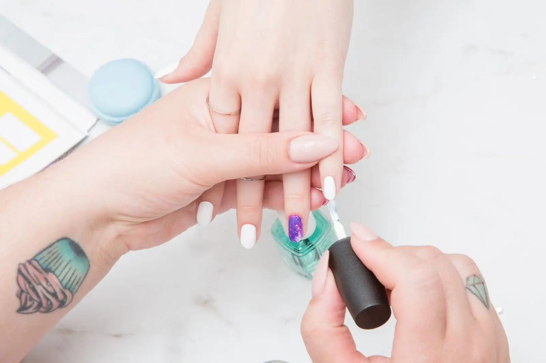 Someone painting a girl's nails