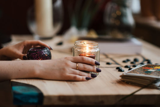 A hand with painted nails and a candle