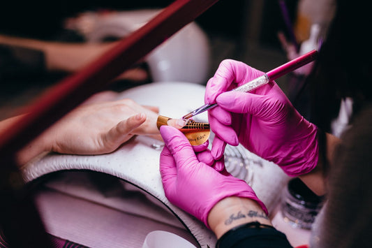 Lady painting a woman's nails