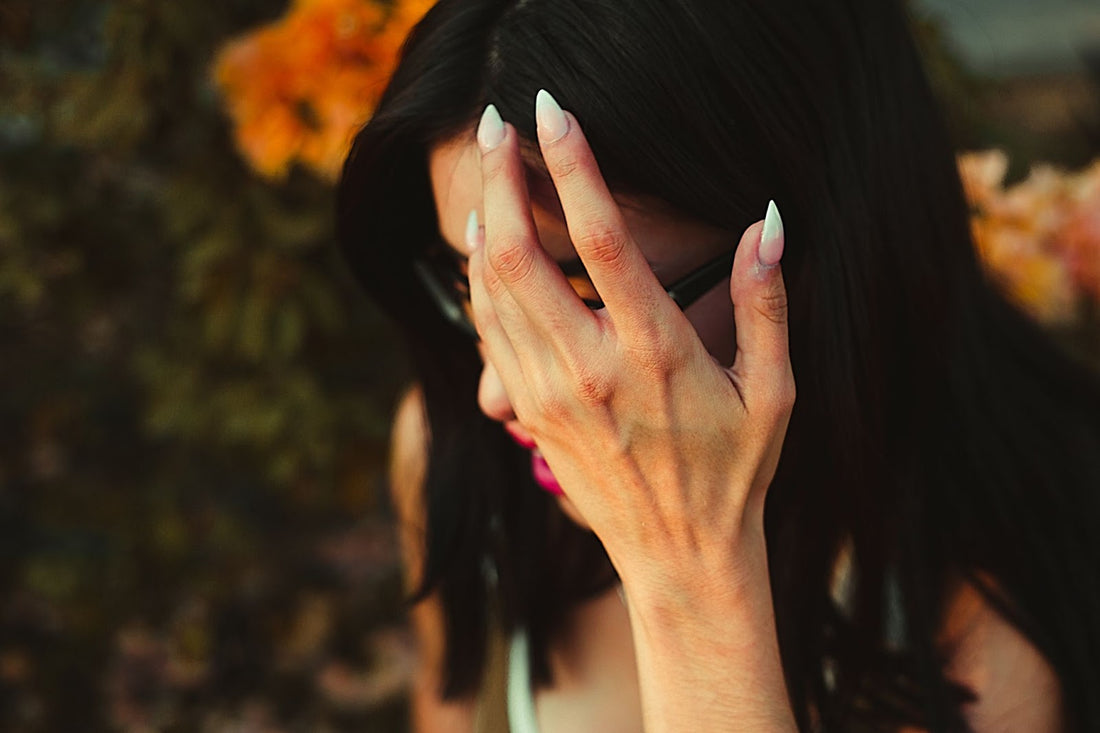 A lady moving the hair out of her eye