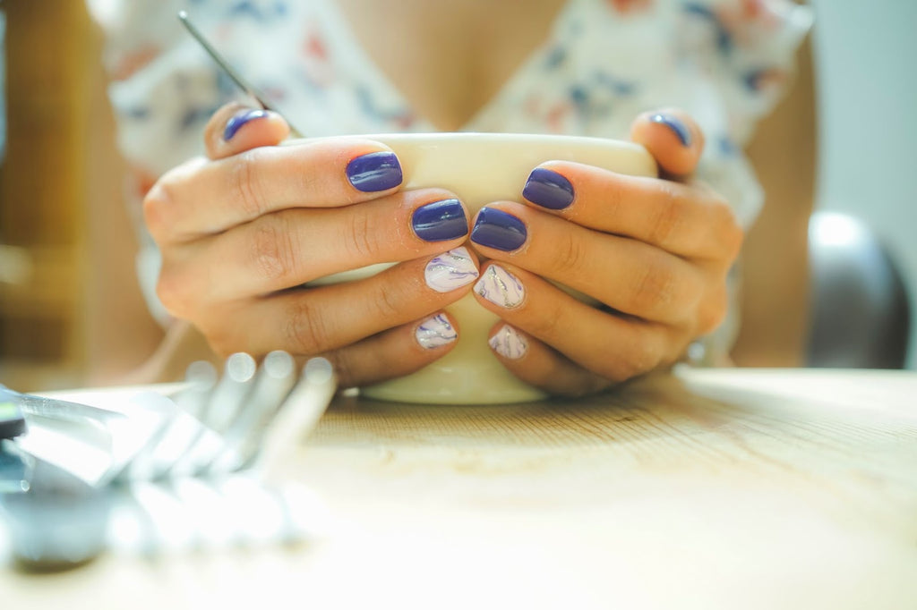 Lady with painted nails holding a cup