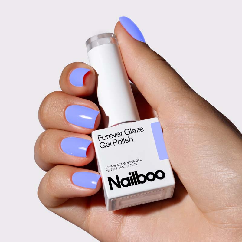 Hand holding bottle of blue Nailboo Forever Glaze Gel Polish.