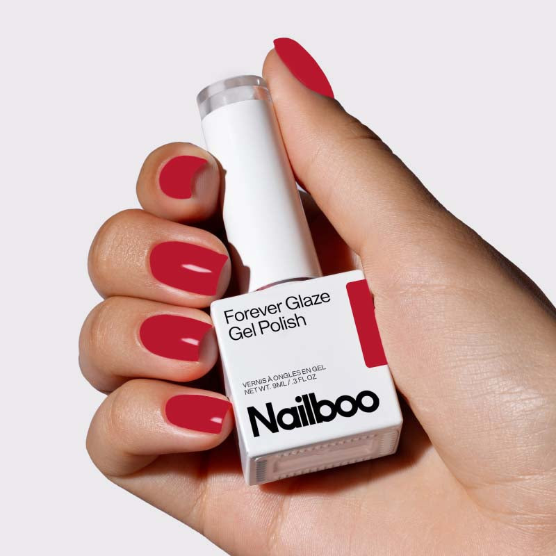 Hand holding red Nailboo Forever Glaze Gel Polish.