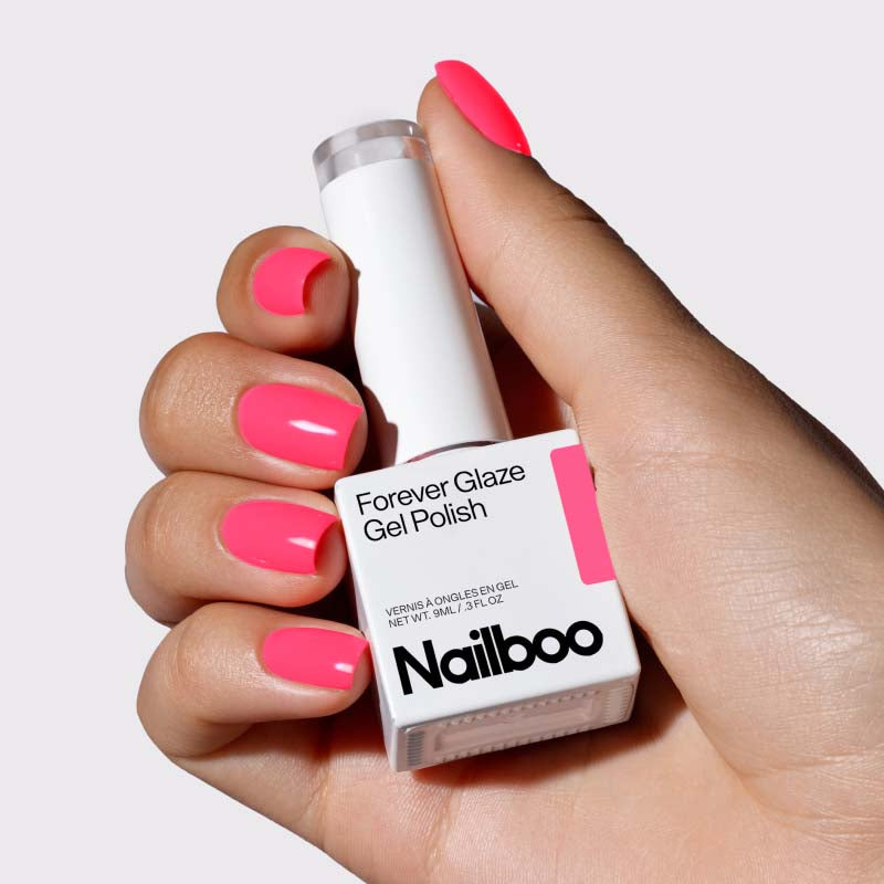 Hand holding Nailboo Forever Glaze Gel Polish with bright pink nails.